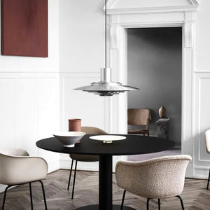 Forma pendellampa i silver över ett ljust matbord